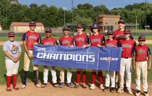 a group of baseball players holding a north carolina usssa tournament banner