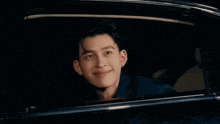 a young man looks out of a car window at night