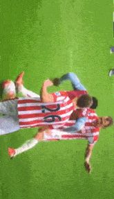 a soccer player wearing a red and white striped jersey with the number 26 on it