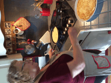 a woman in an apron is cooking on a stove top