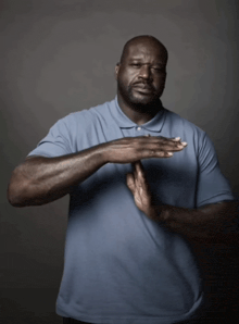 a man in a blue shirt is making a funny face