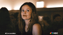 a woman in a dark room with a nbc logo in the corner