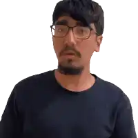 a man with glasses and a beard is pointing at the camera