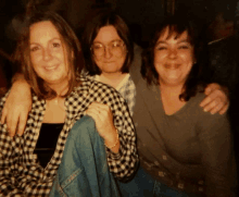 three women are posing for a picture and one is wearing glasses