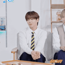 a man wearing a tie is sitting in a chair