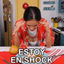 a woman sitting at a table with a plate of food and the words estoy en shock above her head