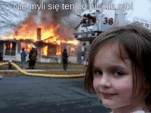 a little girl is smiling in front of a burning house with a fire truck in the background .