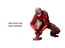 a man kneeling down with the words the bomb has been planted behind him