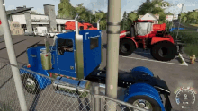 a blue semi truck is parked next to a red tractor in front of a building that says west central