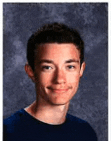 a young man in a blue shirt is posing for a picture .