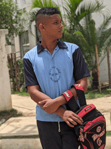 a young man wearing a blue shirt that says let 's play cricket defence