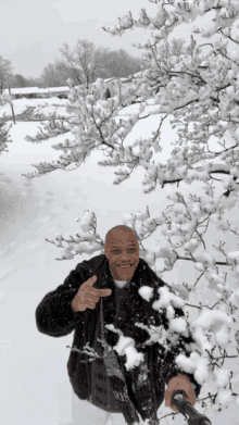 a man in a black jacket is standing in the snow