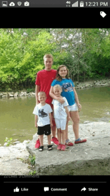 a group of children posing for a picture on a river bank