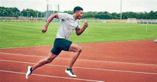 a man is running on a track on a stadium .