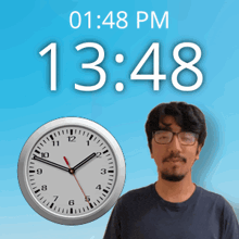a man with glasses stands in front of a wall clock that says 13:48