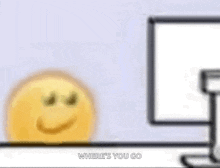 a cartoon smiley face is sitting in front of a computer screen .