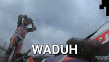 a man standing next to a motorcycle with the word waduh on the bottom