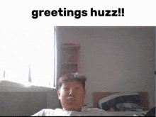 a man is sitting in front of a window with the words greetings huzz written above him