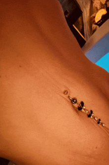 a close up of a person 's stomach with a belly button piercing