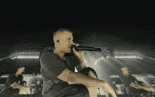 a man singing into a microphone on a stage in front of a crowd