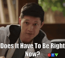a man is sitting in front of a sign that says does it have to be right now ? ctv