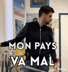 a man in a black jacket stands in front of a wall that says mon pays va mal on it