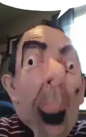 a man wearing a mr bean mask is making a funny face while taking a selfie .