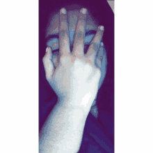 a person covering their face with their hands with their fingers visible