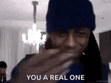 a man wearing a blue hat is holding a piece of food in his hand .