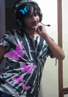 a man wearing headphones and a tie dye shirt with purple butterflies on it