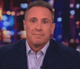a man in a suit and tie is covering his mouth with his hands .