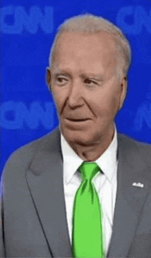 a man in a suit and tie is standing in front of a cnn background .