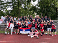 a group of soccer players posing for a photo with a flag that says serbia on it