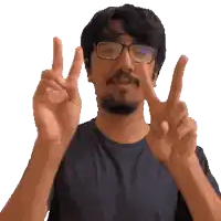 a man with glasses and a beard giving the peace sign