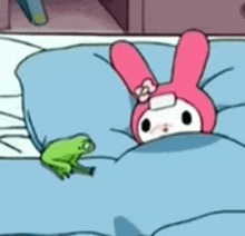 a frog is sitting next to a pink rabbit on a bed .