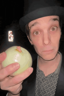 a man wearing a top hat is holding a ball with a sticker on it