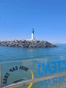 a sign that says uaeta on it with a lighthouse in the background