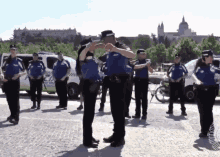 a group of police officers are dancing in front of a white van that says ' policia ' on it