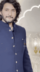 a man wearing a blue jacket with the word v written on the pocket