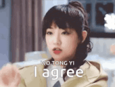 a close up of a woman 's face with the words `` wo tong yi i agree '' on the bottom .