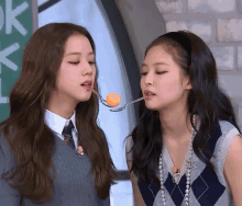 a girl with a spoon in her mouth and another girl with a spoon in their mouth