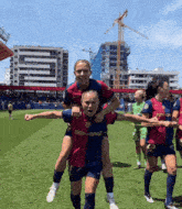 a female soccer player is carrying another female player on her back
