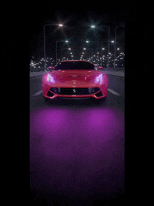 a red ferrari is driving down a dark street at night