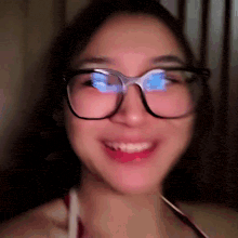 a close up of a woman wearing glasses with a blurry background