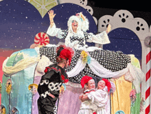 a woman in a black and white polka dot dress is sitting on a candy cane