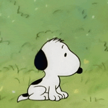 a black and white cartoon dog is sitting in the grass looking up .