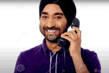 a man wearing a turban is talking on a telephone