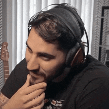 a man wearing headphones and a black shirt that says ' real adventures ' on it