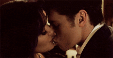 a man and a woman are kissing each other in a room .