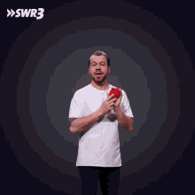 a man in a white t-shirt is holding a slice of watermelon in front of a swr3 logo